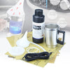 A kit for headlight restoration showing a liquid, a vaporizer, and a metal mug with various related components.