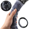 A hand is holding a gray plush steering wheel cover, with an inset showing the cover on a car steering wheel.