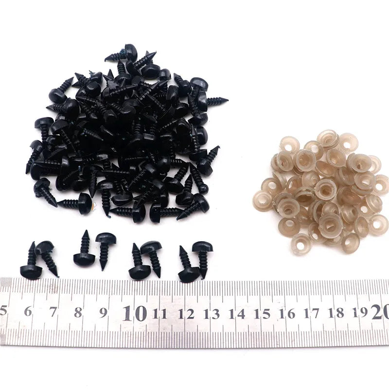 A pile of black safety noses with washers and a row of light tan noses measured against a ruler.