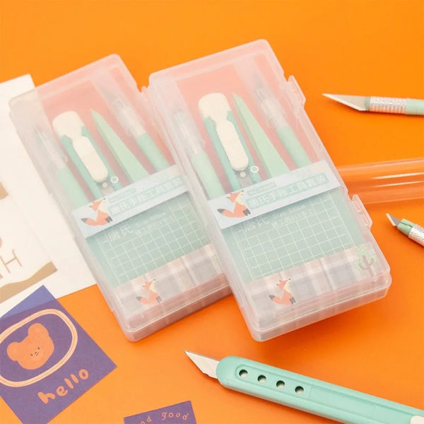 A clear plastic storage box containing a set of precision art cutting tools and blades on an orange background.