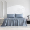 Luxuriöses Bambus-Bettlaken-Set in Hellblau, drapiert über einem Bett mit weißen Wänden und natürlichem Licht.