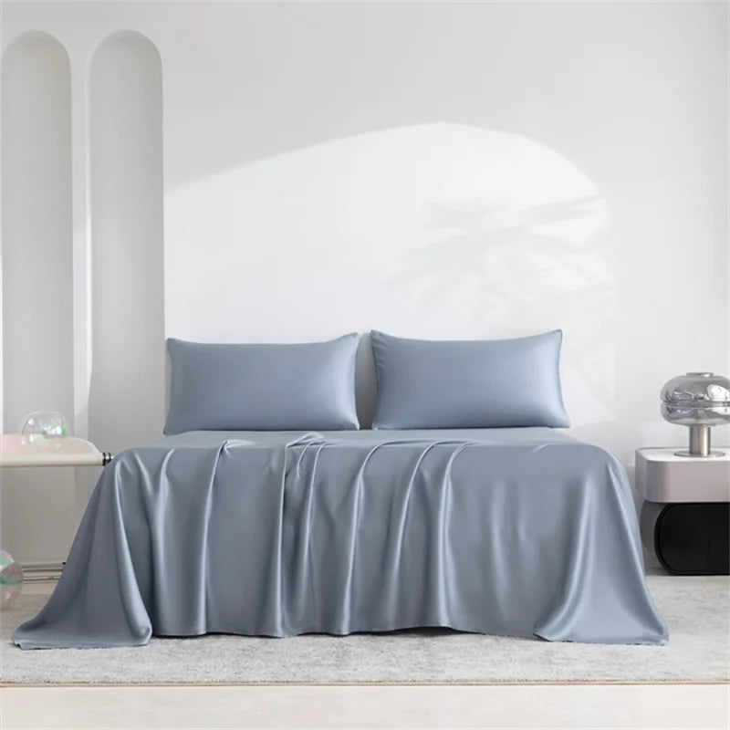 Luxuriöses Bambus-Bettlaken-Set in Hellblau, drapiert über einem Bett mit weißen Wänden und natürlichem Licht.