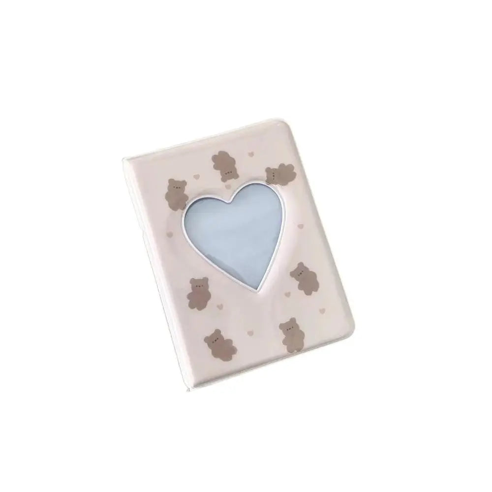 A square photo album cover with a light pink background and a heart-shaped cutout in the center.