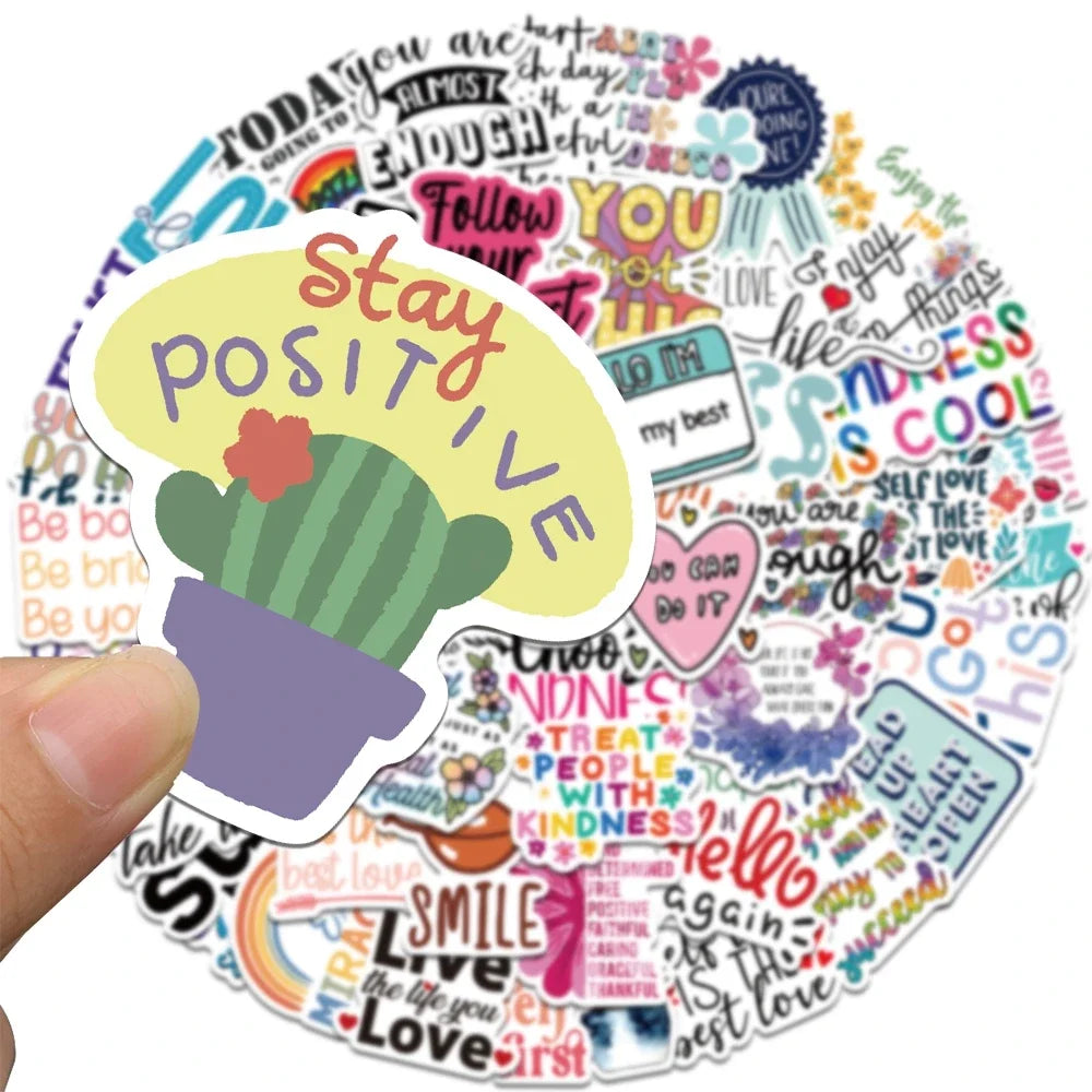 Eine Hand hält ein Aufkleber-Set mit inspirierenden Zitaten, darunter den Text „Stay Positive“, umgeben von bunten positiven 