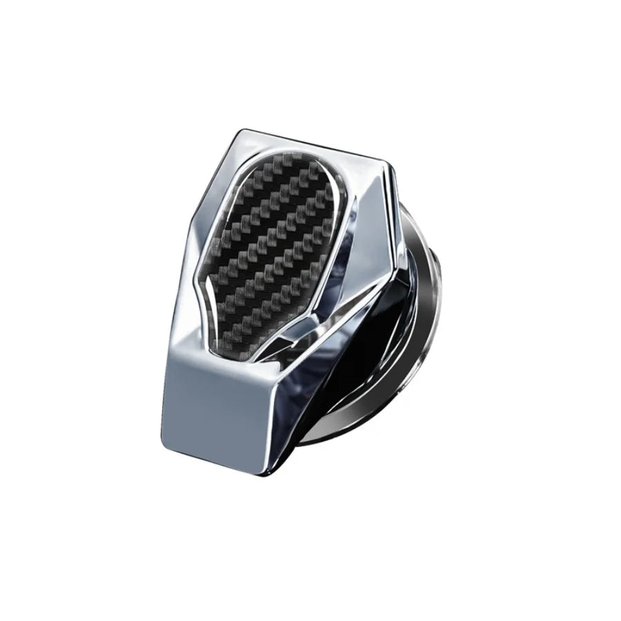 A close-up view of a polished metal button cover and engine switch decal for a car interior.