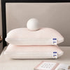 Une pile d'oreillers rembourrés roses et matelassés pour le cou et le soutien cervical sur une surface blanche.