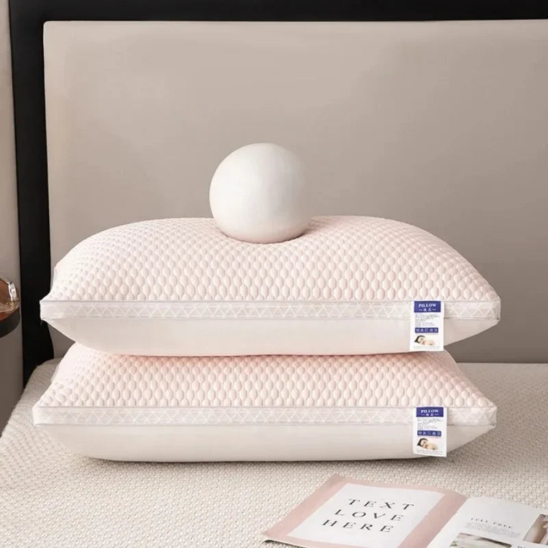 Une pile d'oreillers rembourrés roses et matelassés pour le cou et le soutien cervical sur une surface blanche.