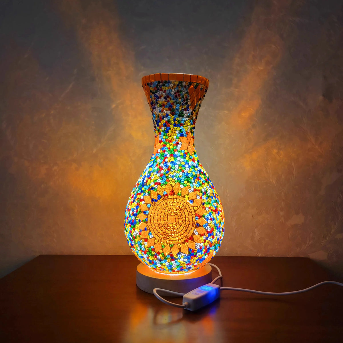 A handcrafted Turkish mosaic table lamp glowing with warm LED light on a wooden surface.