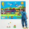 A child stands in front of a colorful felt board featuring various vehicles, animals, and a hot air balloon.