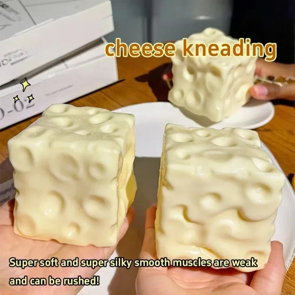 A close-up of a white cheese kneading squishy toy being squeezed by hands.