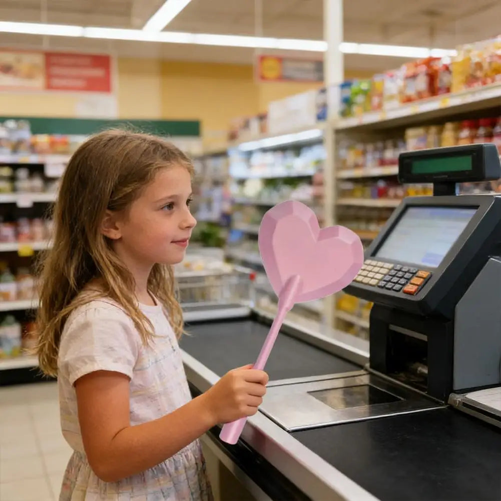 A young girl is using a pink star-shaped contactless card payment wand at a checkout counter.