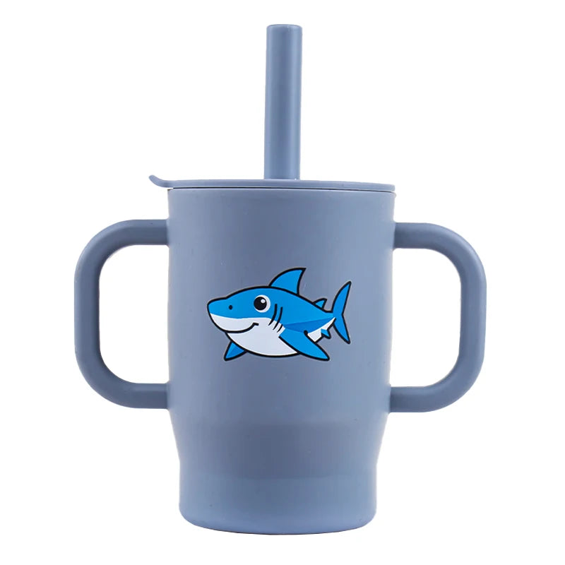 A light blue silicone training cup with a straw and handles featuring a blue fish design.