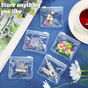 A clear plastic organizer bag filled with various small items like jewelry and pills, set on a blue surface.