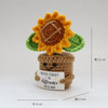 Handcrafted crochet sunflower with green leaves growing out of a brown pot