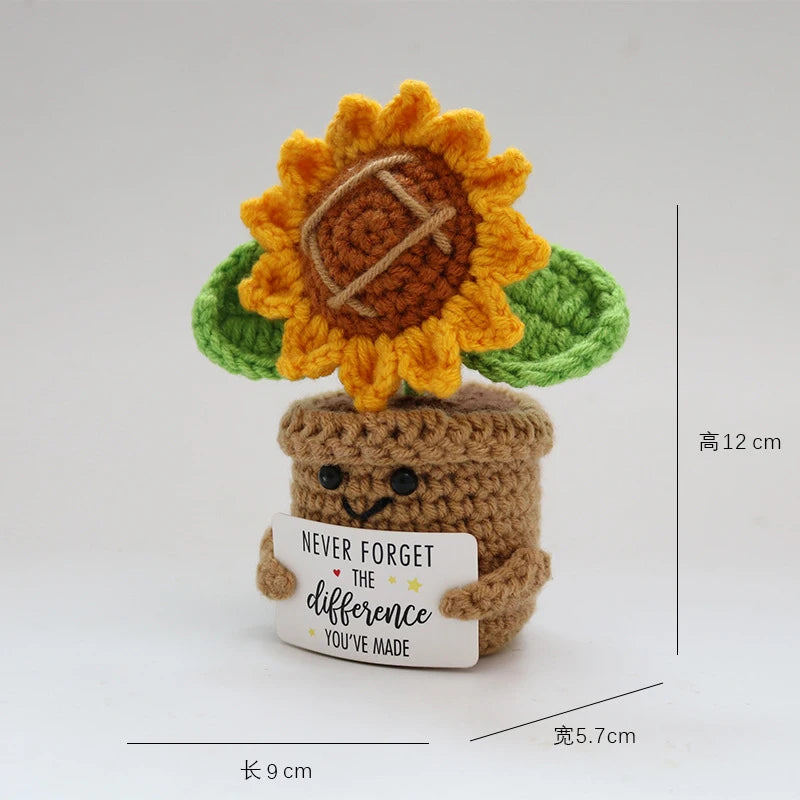 Handcrafted crochet sunflower with green leaves growing out of a brown pot