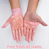 A pair of pink nitrile gloves are shown on a hand, demonstrating they are free from oil stains.