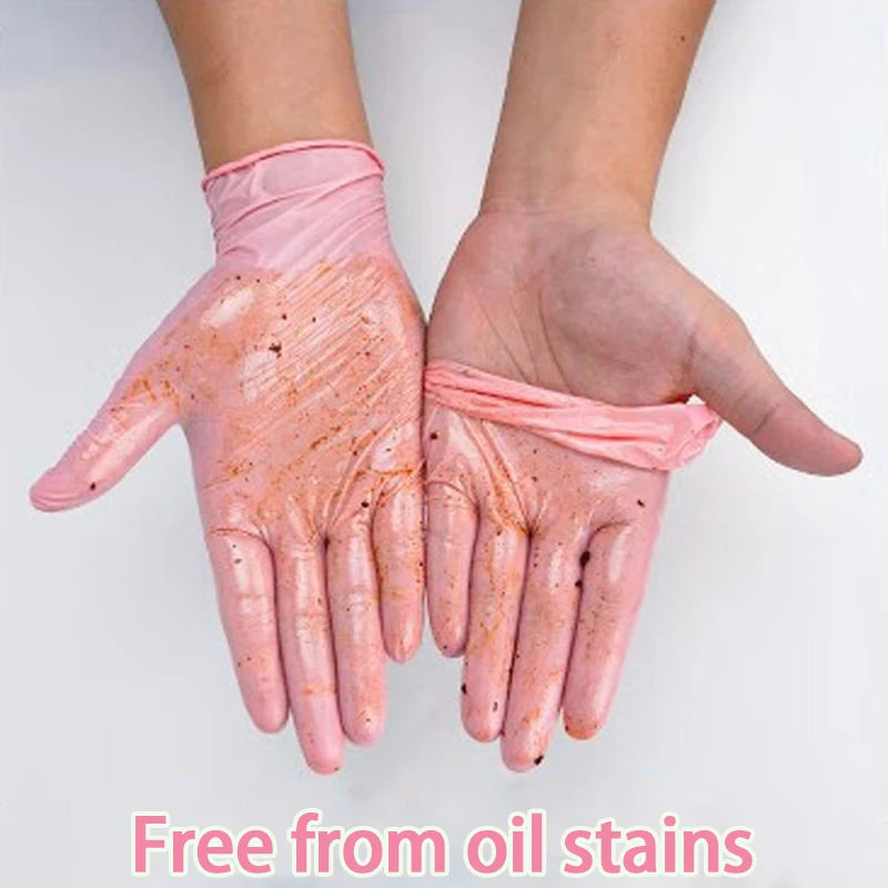 A pair of pink nitrile gloves are shown on a hand, demonstrating they are free from oil stains.