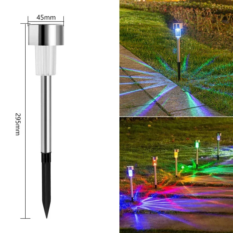 A vertical garden lantern light with a silver top and black base, illuminating a pathway with colorful light beams.