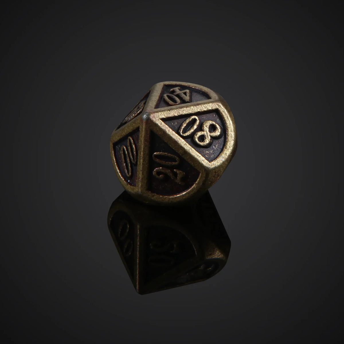 A bronze metal polyhedral dice set, likely a d10, is shown resting on a reflective surface.