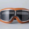 A pair of brown leather retro foldable motorcycle goggles with black lenses and silver trim.