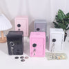 A collection of vintage metal piggy banks in pink, gray, and black, displayed on a white surface with some US currency.