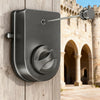 A dark gray retractable clothesline with a locking system mounted on a wooden wall.