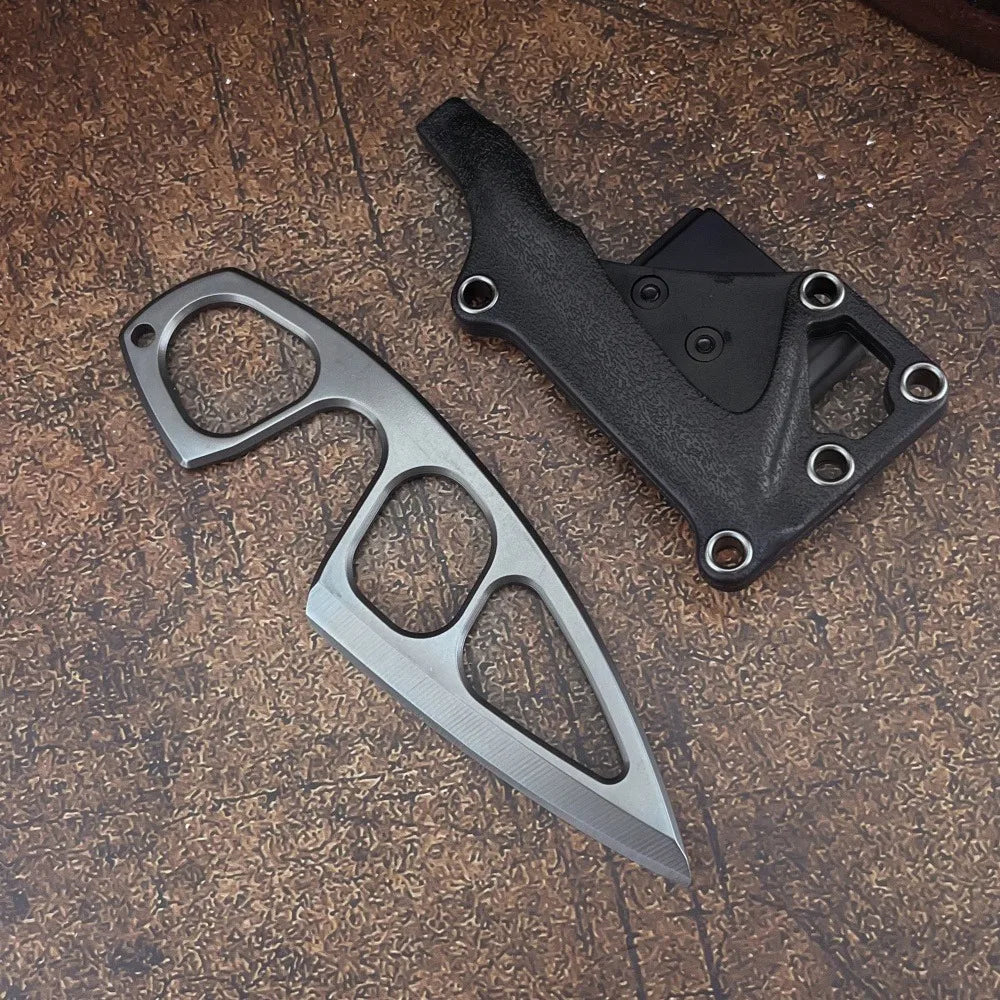 A compact stainless steel neck knife with a black sheath resting on a wooden surface.