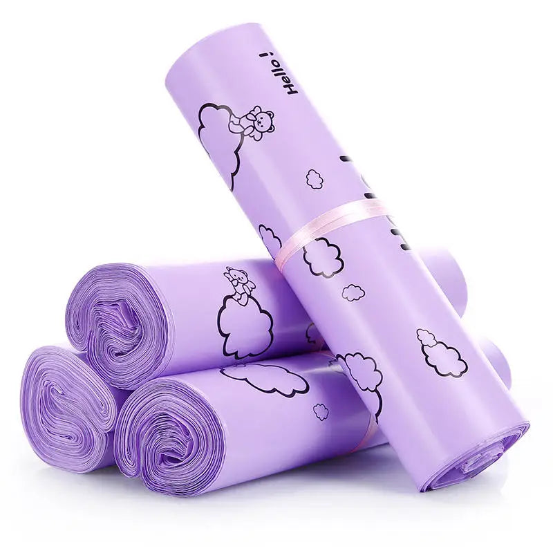 A roll of purple self-sealing mailing bags featuring a white cloud and bear design.
