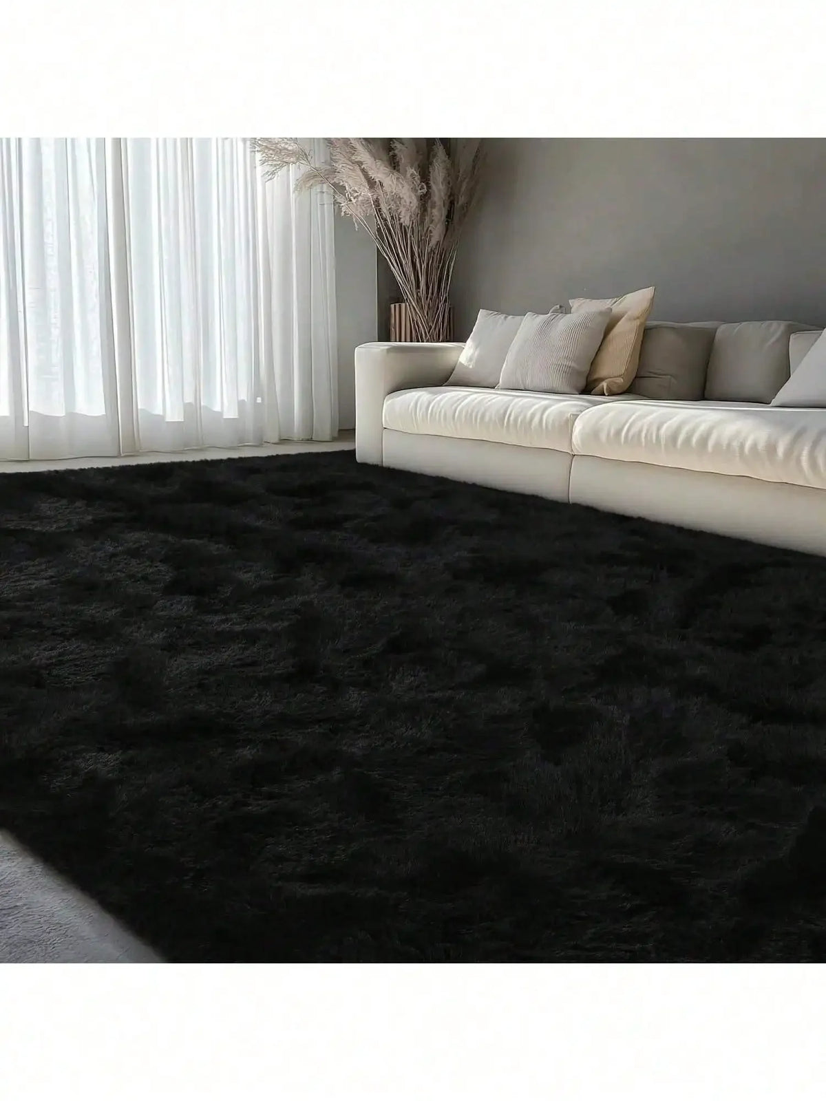 Dunkelgrauer, flauschiger Teppich mit langer Flor in einem modernen Wohnzimmer mit durchscheinenden weißen Vorhängen und eine
