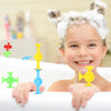 A smiling toddler wearing a white foam headband holding various colorful silicone suction bath toys.