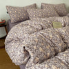 A set of soft printed duvet covers and pillowcases in a muted taupe color with a floral pattern.
