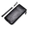 Schwarzes Kunstleder-Herrengeldtasche mit schwarzem Riemen diagonal dargestellt.