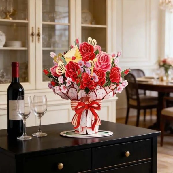 A vibrant bouquet of red and pink roses and cherry blossoms displayed in a white vase on a dark table.