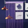 A purple beaded string curtain hangs, featuring a white heart design and the word LIVE.