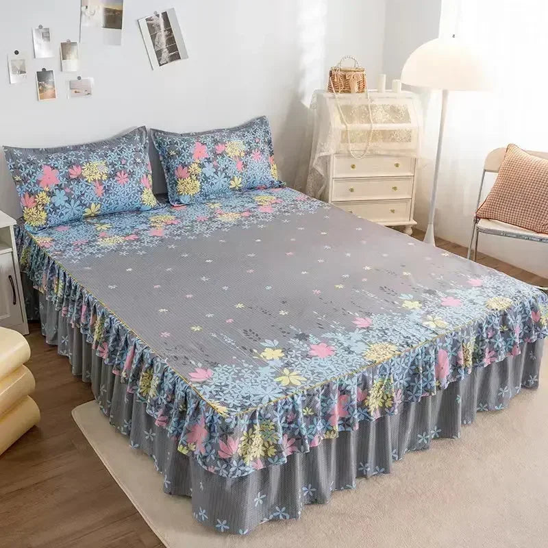 Jupe de lit à double couche imprimée gris et bleu sur un lit.