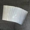 A fan of clear plastic card sleeves stacked diagonally on a dark surface.
