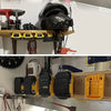 A black battery storage holder is mounted on a wooden shelf, showing various yellow and black battery components.