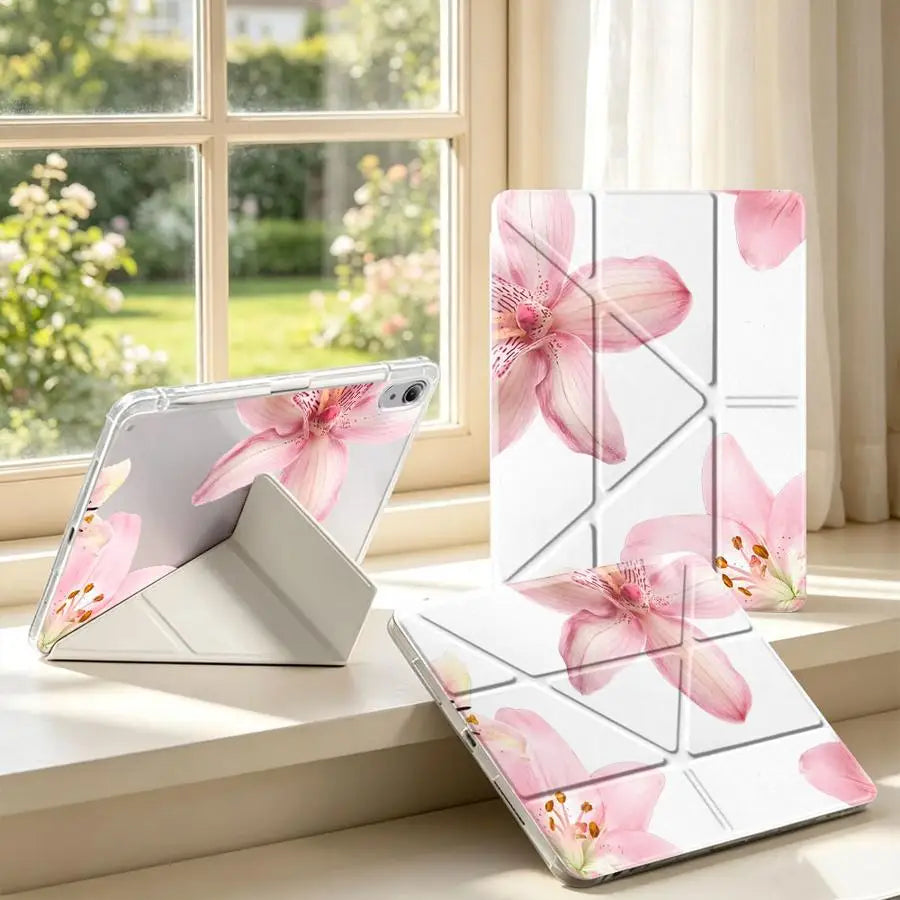 A pink lily flower tablet case with a pen holder is displayed on a windowsill next to a smartphone.