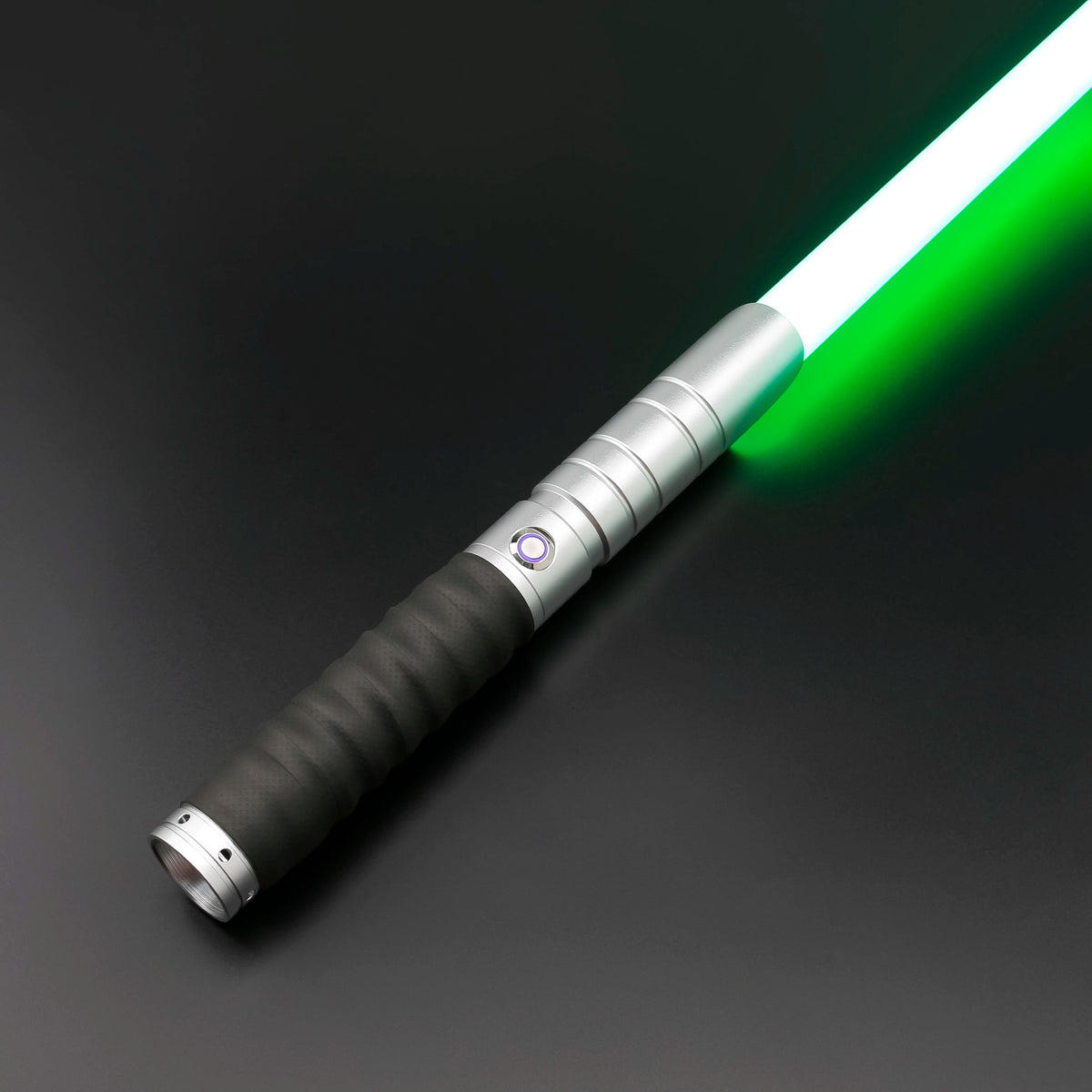 A silver lightsaber with a green blade and black grip is shown diagonally against a dark background.