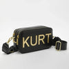 Schwarze Ledertasche mit goldenen Aufschriften und einem schwarzen Riemen