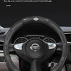 A black carbon fiber pattern steering wheel cover for a Nissan vehicle.