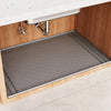 A silicone mat protecting the bottom of a kitchen cabinet under the sink.