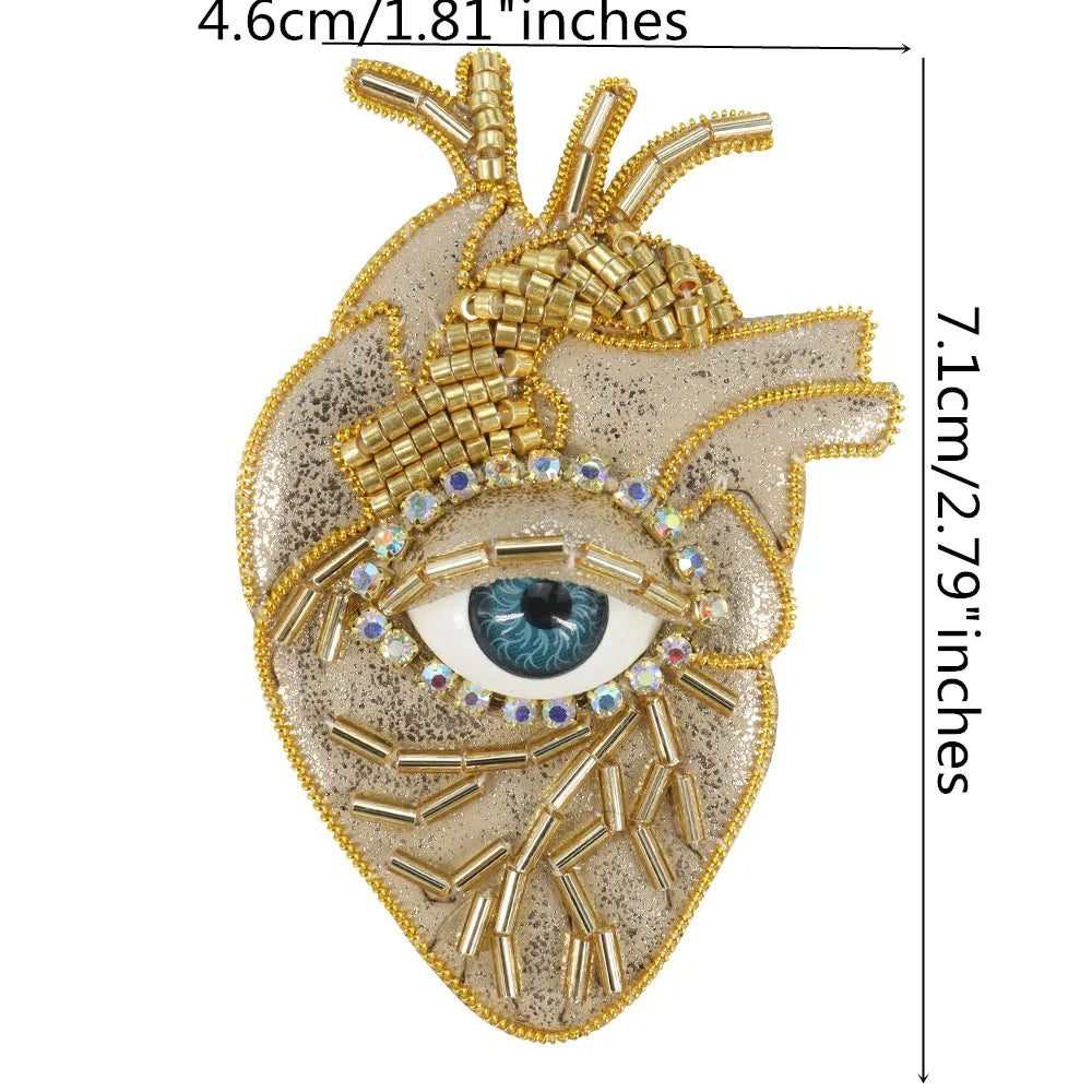 A detailed, sparkling beaded rhinestone patch shaped like an eye and surrounding facial features.