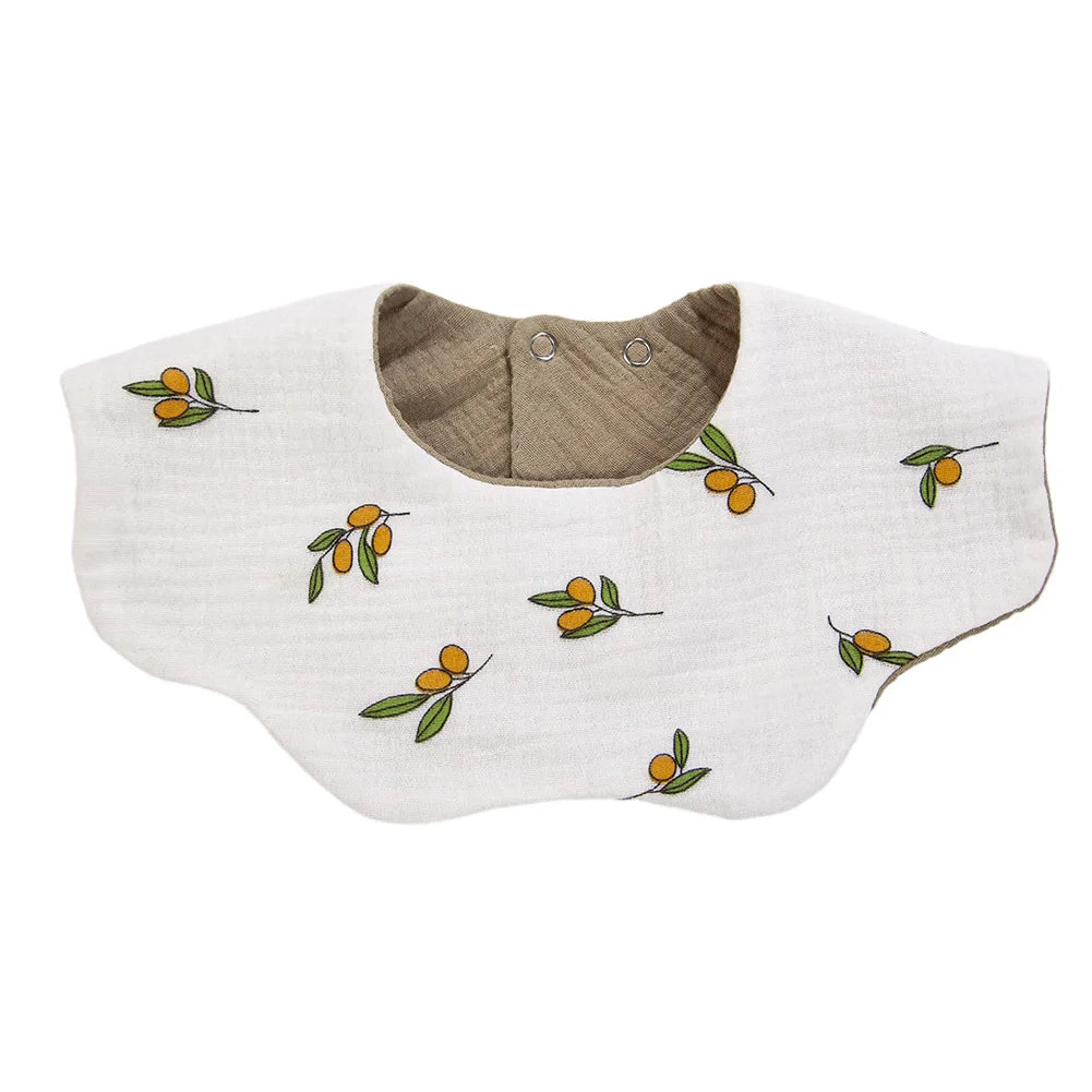 A light beige muslin cotton baby bib or burp cloth with a brown snap closure and small orange-yellow leaves printed on it.