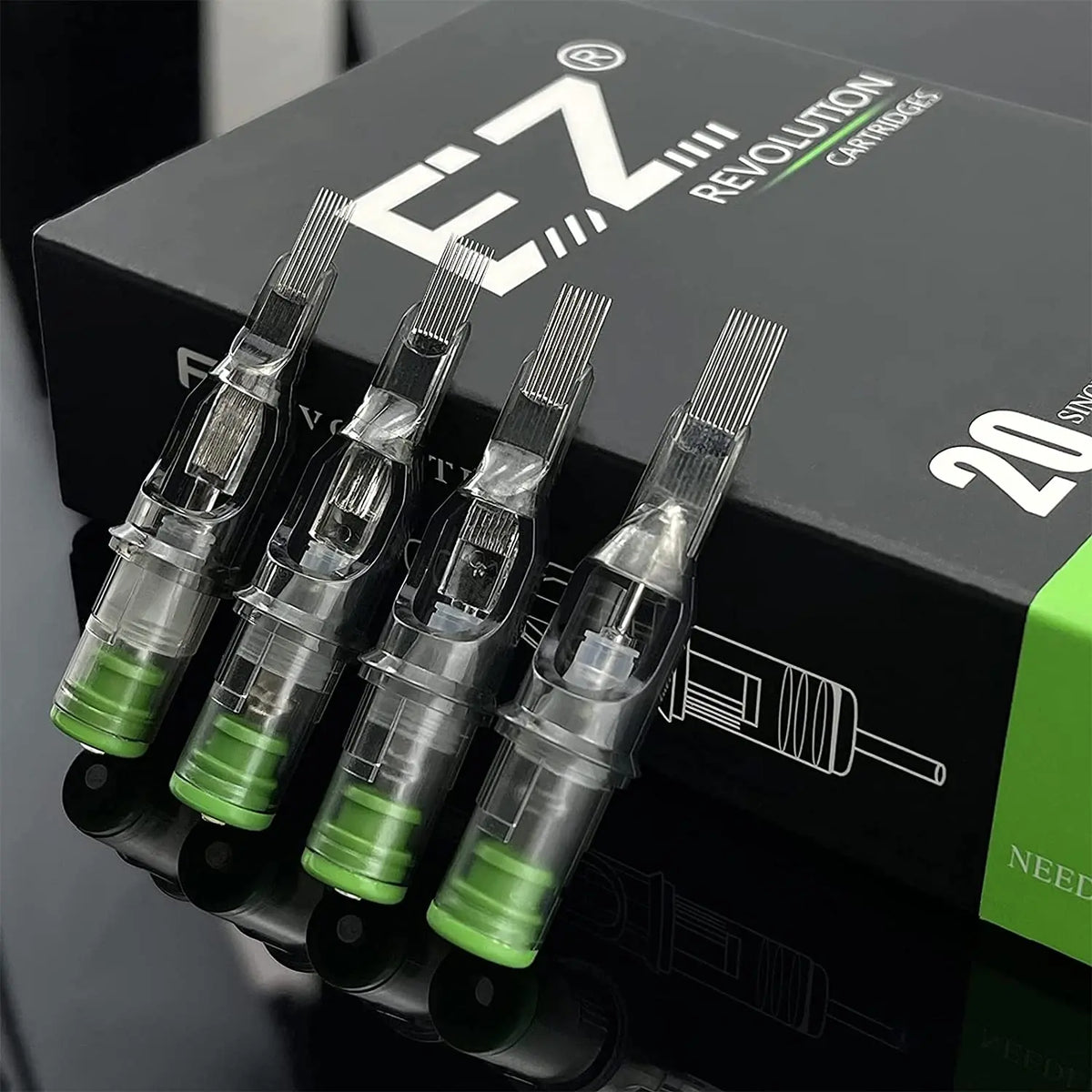 A box of EZ Revolution cartridges for professional tattoo needles, showing several long tapered syringes.