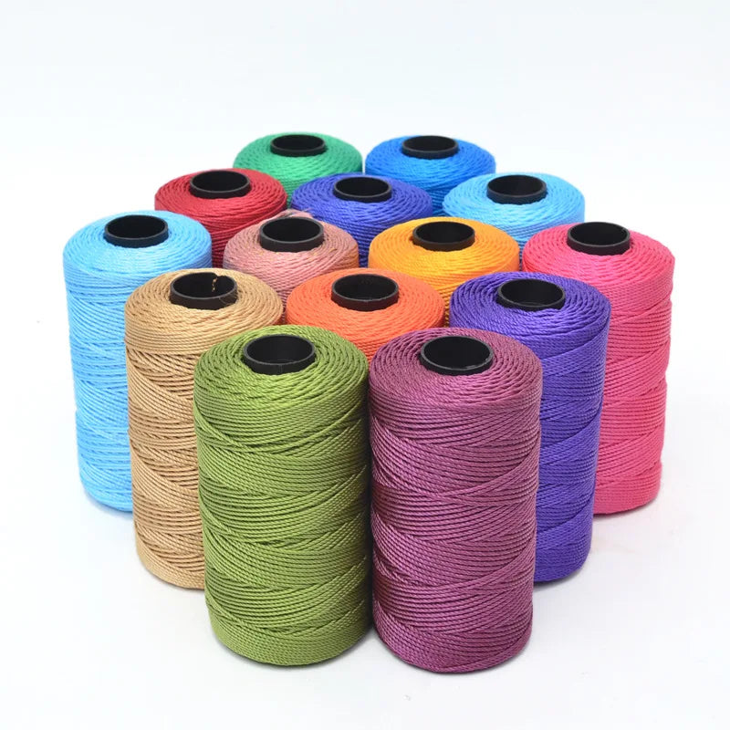 A collection of multicolored 3-ply polyester knitting yarn spools in various shades including blue, green, orange, and pink.