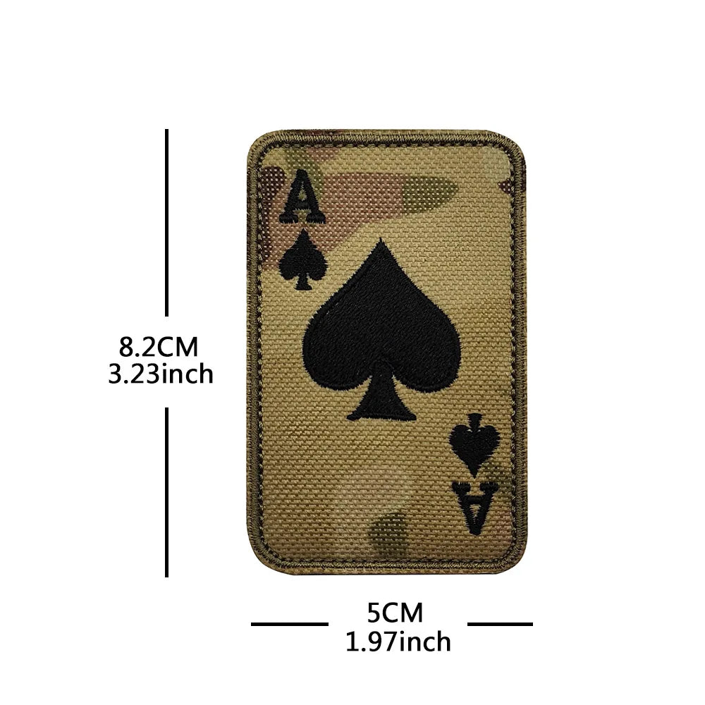 A rectangular embroidered patch featuring the Ace of Spades with a skull design on a tan fabric background.