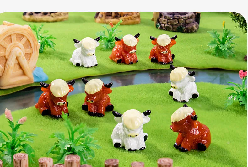 A collection of adorable resin Highland cow figurines in white and orange colors displayed on green mossy terrain.