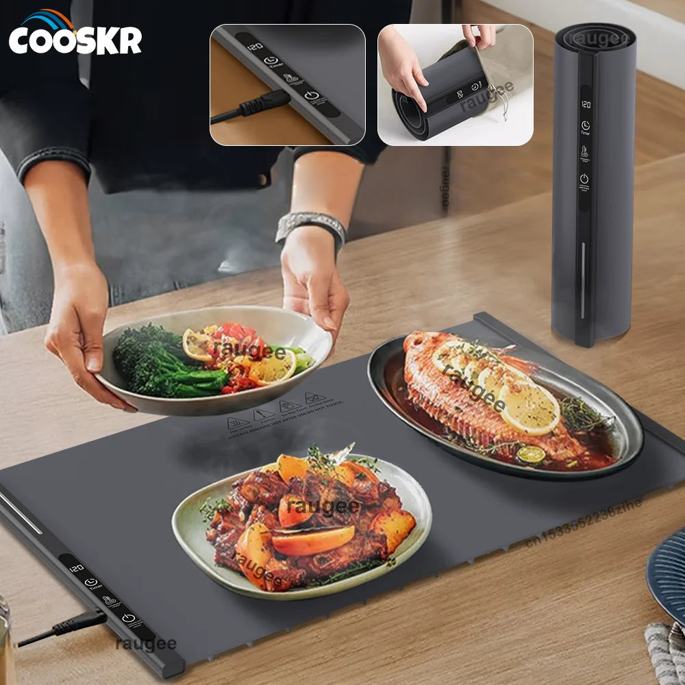 A foldable electric food warming tray is shown with various cooked foods on a cutting board and a vertical storage container.