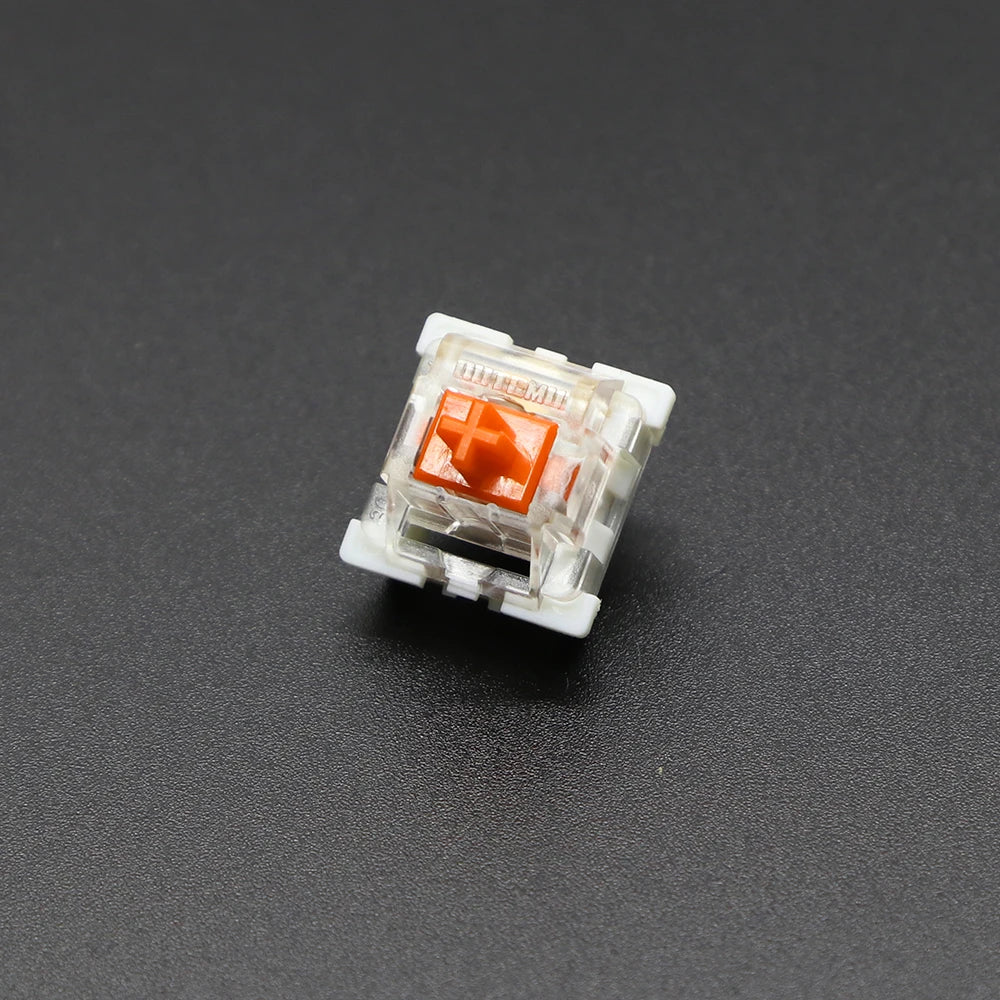 A close-up view of an Outemu mechanical keyboard switch, featuring a white housing and an orange-colored stem.